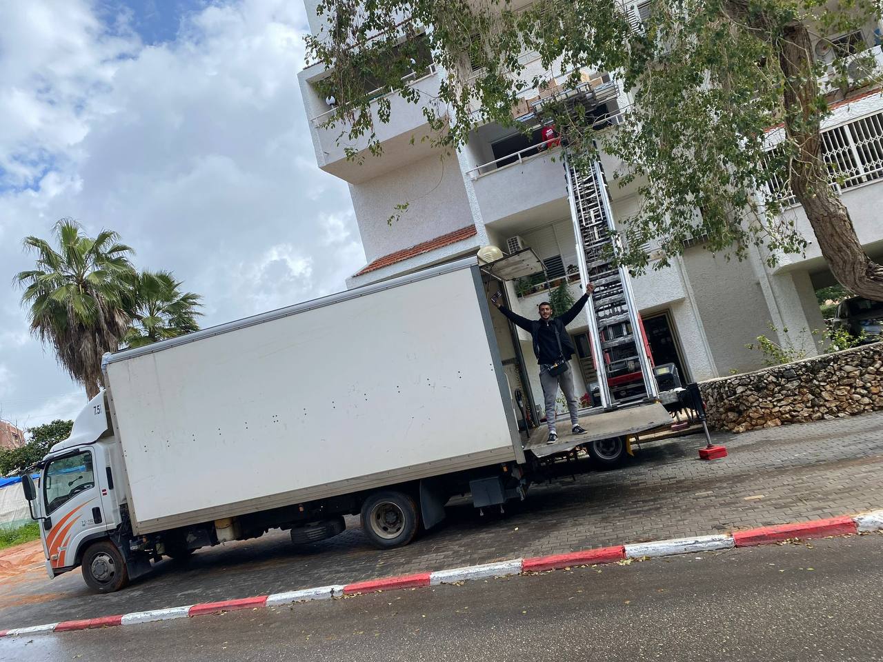 משאית ההובלות של לוי הובלות עם מעלית חיצונית בזמן הובלת דירה בבניין מגורים